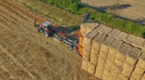 Big bales of straw being stacked in a field