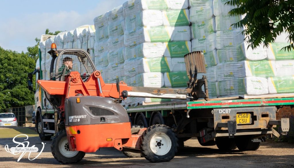 Sundown bedding bales being unloaded from a lorry with a forklift