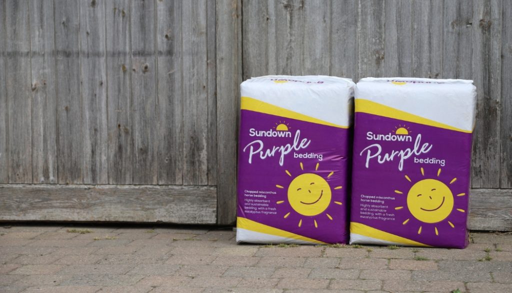 Two bales of Sundown Purple bedding against a wooden door