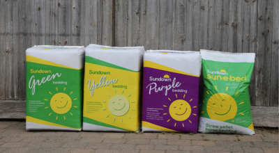 equine range Three bales and a bag of horse bedding lined up against a wooden door