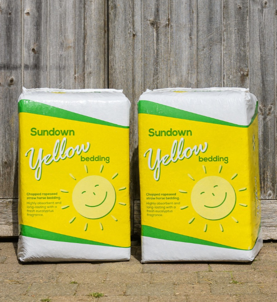 two bales of sundown yellow in front of a wooden barn door